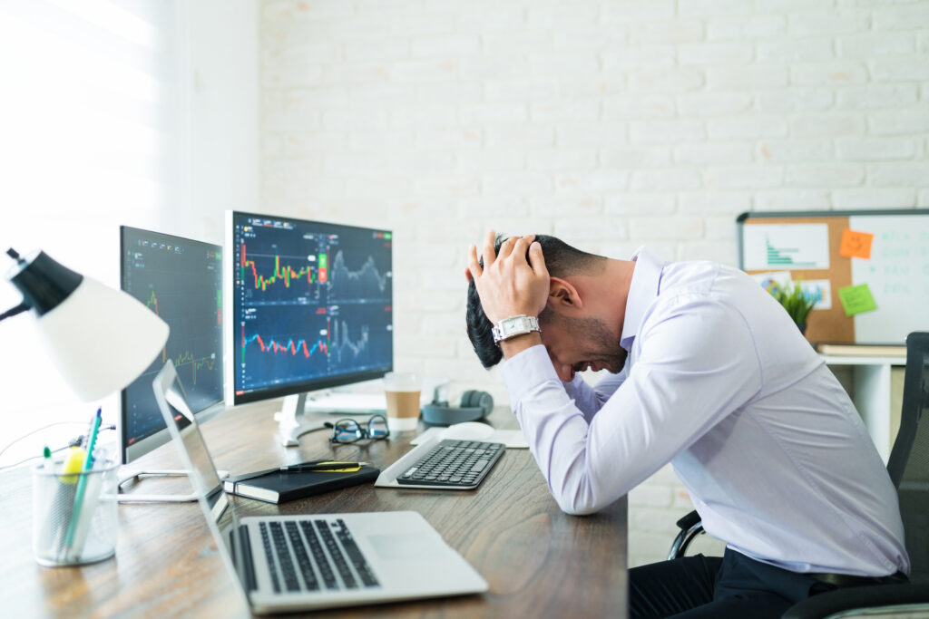 Trader is sitting and feeling stress after loss big money from investing